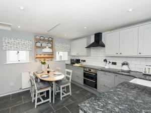 a kitchen with a table and chairs in it at Crescent Cottage in Askham