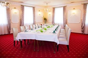 a long table with white tables and chairs in a room at Hotel Schloßblick Trebsen in Trebsen