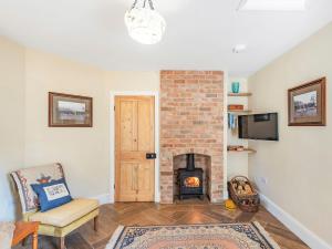 a living room with a brick fireplace and a chair at Lion Gate Lodge in Horncastle