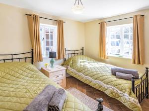 two beds in a room with two windows at Lion Gate Lodge in Horncastle