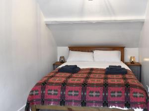a bedroom with a bed with a red and black blanket at Caer Pwll in Morfa Nefyn