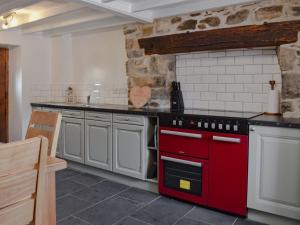 a kitchen with a red oven in a room at Caer Pwll in Morfa Nefyn