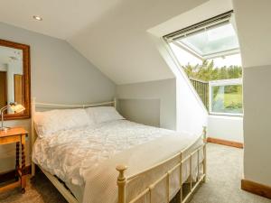 a bedroom with a bed and a window at Loadbrook Barn in Ughill