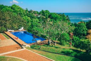 an aerial view of a swimming pool and the ocean at Highland Villa in Weligama
