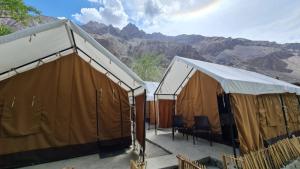 zwei große Zelte mit Tischen und Stühlen in den Bergen in der Unterkunft BORDER CAFE AND CAMPS TURTUK BY TRAVELCULTS in Turtok