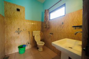 a bathroom with a toilet and a sink and a window at Chitwan Gaida Lodge Pvt. Ltd. in Sauraha