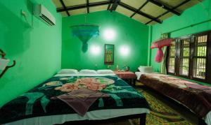 a bedroom with green walls and a bed with flowers on it at Chitwan Gaida Lodge Pvt. Ltd. in Sauraha