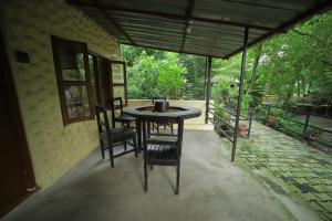 einen Tisch und Stühle auf einer Terrasse in der Unterkunft Chitwan Gaida Lodge Pvt. Ltd. in Sauraha