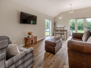 a living room with two couches and a table at Dwrgi - Uk32923 in Cwrt-newydd