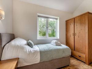 a bedroom with a bed and a window at Dwrgi - Uk32923 in Cwrt-newydd
