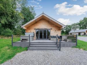 a log cabin with a porch and stairs in front at Dwrgi - Uk32923 in Cwrt-newydd