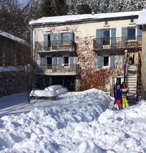 eine Gruppe von Menschen, die im Schnee vor einem Gebäude stehen in der Unterkunft Maison Sarda in Formiguères