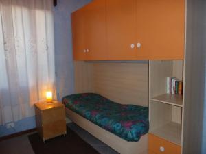 Un pequeño dormitorio con una cama y una vela sobre una mesa en Sissi Bed&Breakfast, en Tencarola