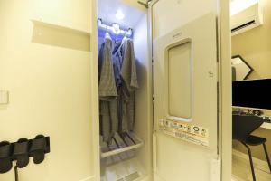 una cabina armadio con una porta aperta con i vestiti di Hotel Yeosu Yam Hakdong a Yeosu