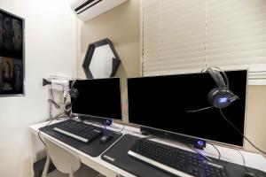 a desk with a computer monitor and a keyboard and headphones at Hotel Yeosu Yam Hakdong in Yeosu