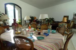 einen Esstisch mit einem gestreiften Tischtuch und Stühlen in der Unterkunft Le Patio 3 Centre ville PÉZENAS in Pézenas