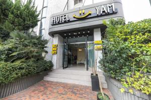 Hotel Yeosu Yam Hakdong في يوسو: مدخل الفندق مع وجود لافته مكتوب عليها فان الفندق