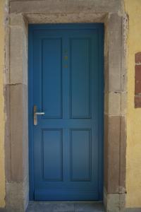 eine blaue Tür in einer Steinmauer in der Unterkunft le 18 bis in Vecoux