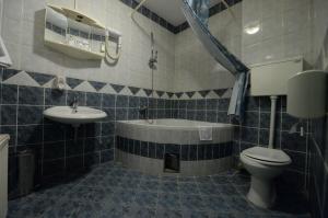 un bagno con vasca, WC e lavandino di Hotel Slodes a Belgrado