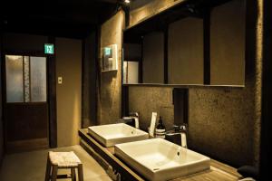 baño con 2 lavabos blancos y taburete en Oito 美しい街並みに佇む喫茶と宿, en Tamba-sasayama