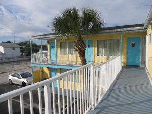 a yellow house with a palm tree in front of it at Skyway Motel in Daytona Beach