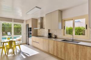 a kitchen with wooden cabinets and a table with chairs at Villa Santa Lucia in El Toro