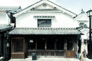 un grande edificio bianco con un grande portone di legno di Oito 美しい街並みに佇む喫茶と宿 a Tamba-sasayama