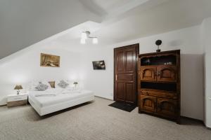 Hotel U Lípy في هرينسكو: غرفة معيشة مع أريكة بيضاء وخزانة خشبية