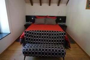 ein Schlafzimmer mit einem Bett mit einer roten Decke und einem Stuhl in der Unterkunft le 18 bis in Vecoux