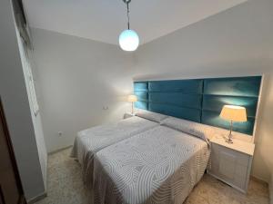 um quarto com uma cama grande e uma cabeceira azul em APARTAMENTO AREVALO LUCENA CENTER em Lucena
