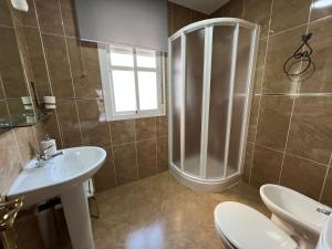 uma casa de banho com um chuveiro, 2 WC e um lavatório. em APARTAMENTO AREVALO LUCENA CENTER em Lucena