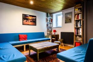 ein Wohnzimmer mit einem blauen Sofa und einem Tisch in der Unterkunft Maison Sarda in Formiguères