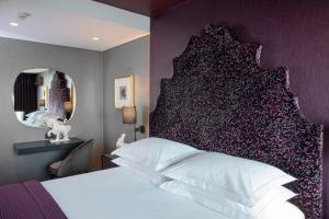 a bedroom with a large bed with a large headboard at President Hotel in Athens