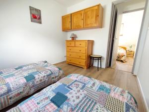 a bedroom with two beds and a dresser at Le Marmandais, T3 lumineux, balcon, parking, wifi, proche thermes, 4 personnes in Luchon