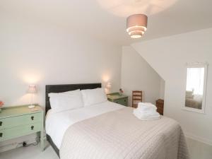 ein weißes Schlafzimmer mit einem Bett und zwei Nachttischen in der Unterkunft St Botolphs in Hornsea
