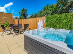 een hot tub in de achtertuin met een tafel en stoelen bij Pea Cottage in Ilchester