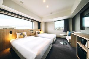小樽的住宿－OMO5 Otaru by Hoshino Resorts，酒店客房设有两张床和电视。