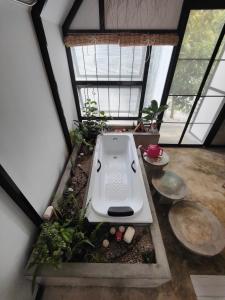 a bathroom with a bath tub in a room with windows at See Sky at Na Rak O Resort in Chiang Rai