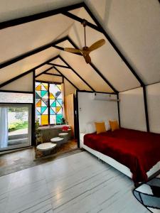 a bedroom with a red bed and a ceiling fan at See Sky at Na Rak O Resort in Chiang Rai