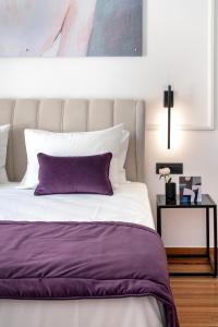 a bedroom with a bed with a purple pillow at Athens Flair in Athens