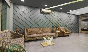 a waiting room with two couches and a tv at Treebo Premium Brijinn in Nagpur