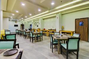 a restaurant with tables and chairs in a room at Treebo Tryst Brijinn in Nagpur