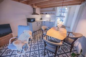 a living room with a table and chairs and a kitchen at 't Pekelhuis - Vakantiehuisje op boerderij Huize Blokland in Hem