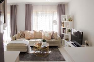 a living room with a couch and a tv at Beautiful 2 bedroom Apartment near Monte Casino in Sandton