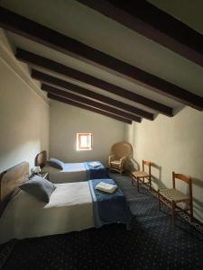 a bedroom with two beds and two chairs at Requesens in La Jonquera