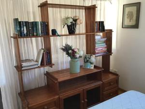 a wooden book shelf with a vase of flowers on it at Monteview Loft Apartment in Herceg-Novi