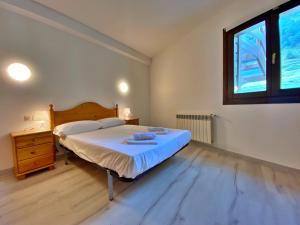 een slaapkamer met een bed, een dressoir en een raam bij Pleta de Peu del Riu hasta 4 personas in Canillo