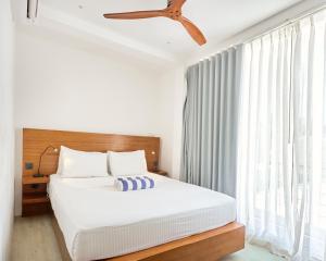 1 dormitorio con 1 cama y ventilador de techo en Bliss Dhigurah en Dhigurah