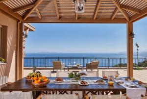 a table with fruit on a patio with a view of the ocean at Villa Omikron in Rodia