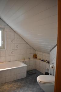 ein Badezimmer mit einem WC und einer Badewanne in der Unterkunft Ferienhaus Heideidyll in Bispingen